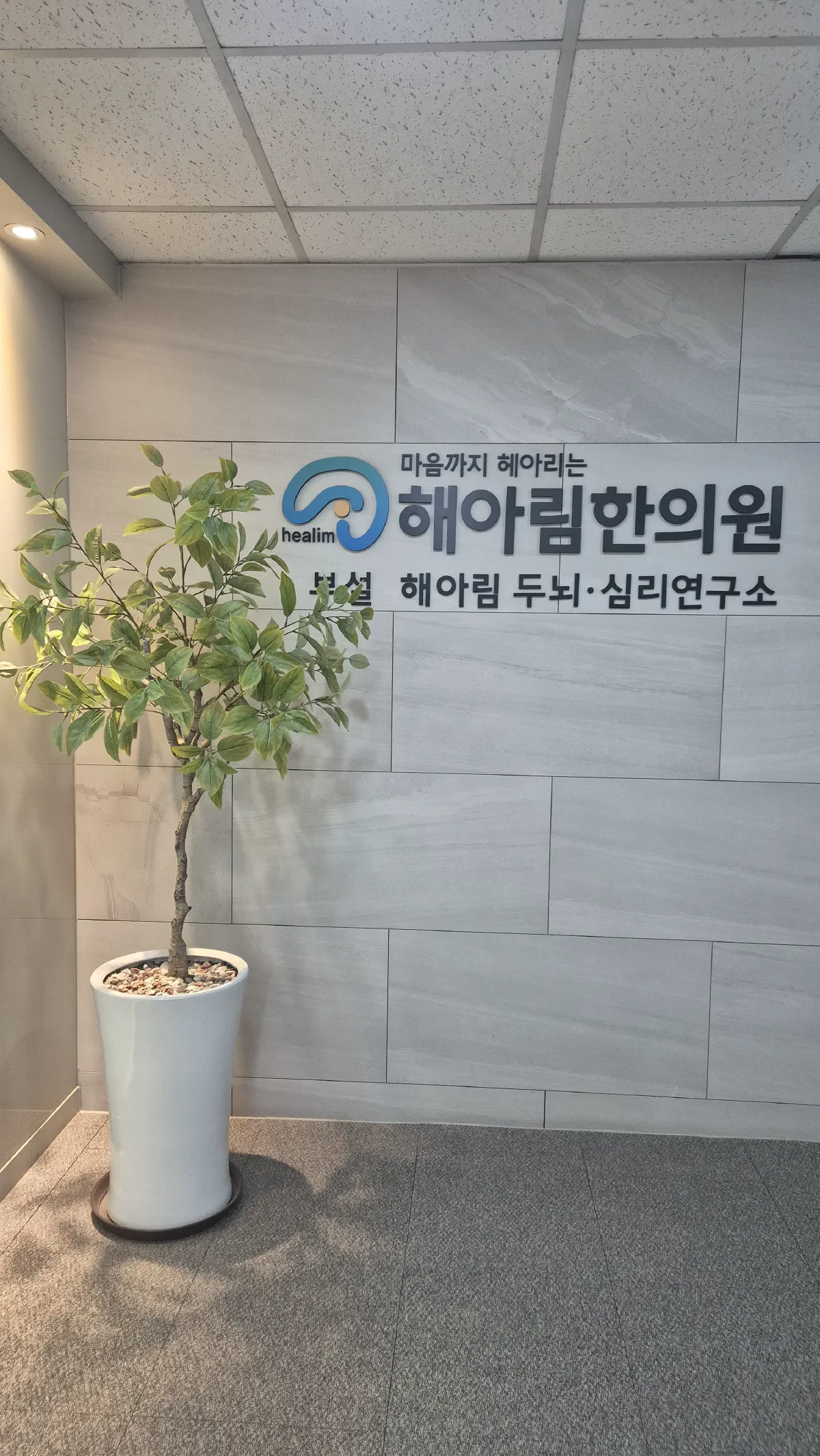 해아림한의원 잠실점 로비의 상호 사인과 부설 해아림 두뇌·심리연구소 표기
